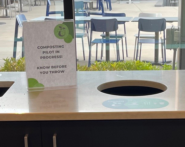 Composting pilot program sign by compost bin